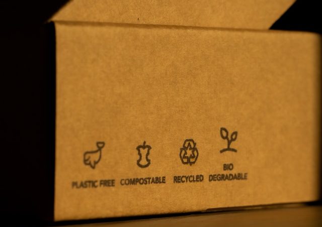 Close up of the size of a box with labels that say plastic-free, compostable, recycled and biodegradable