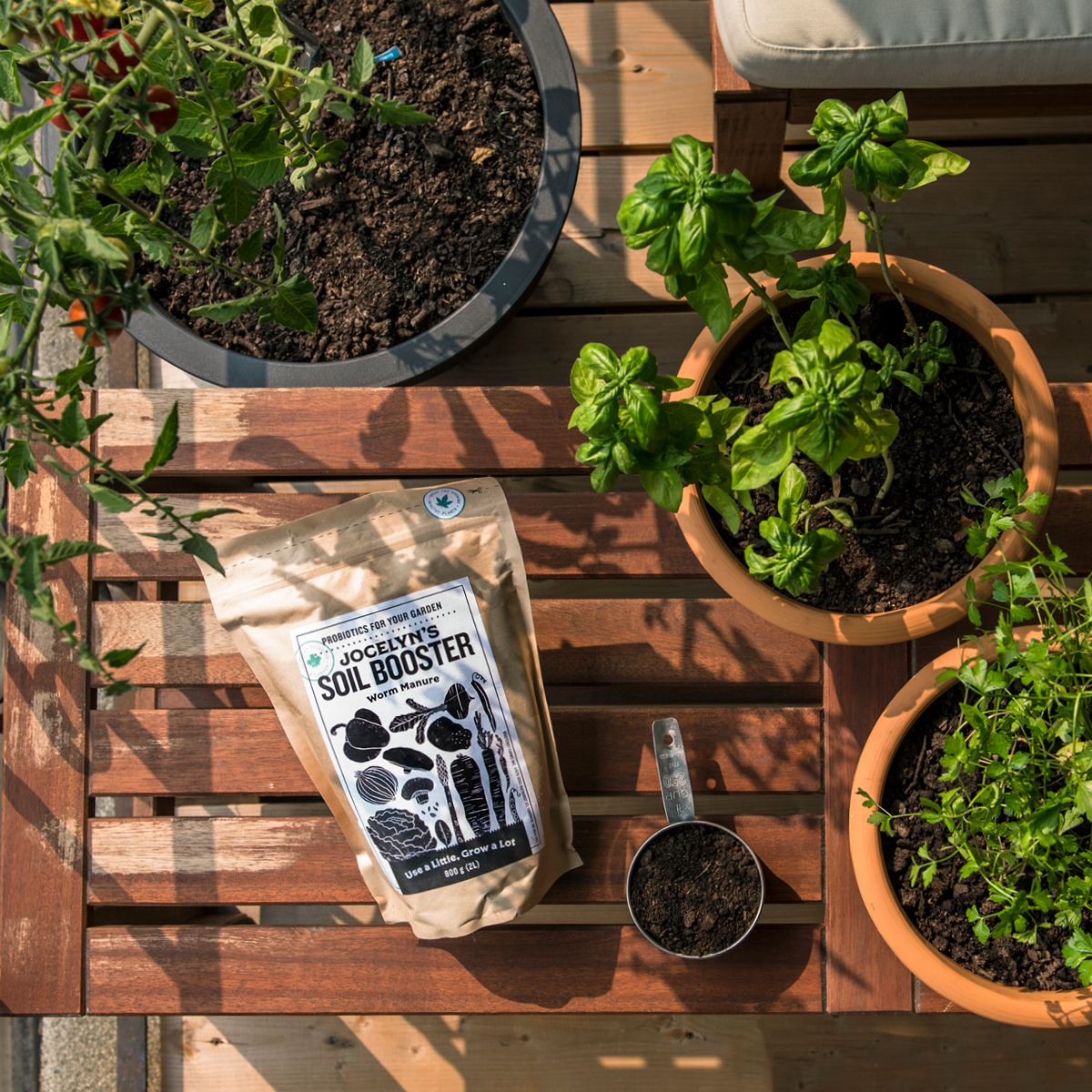 Bag of Jocelyn's Soil booster on a wooden table next to plants