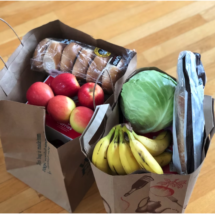 Two brown paper grocery bags filled with produce