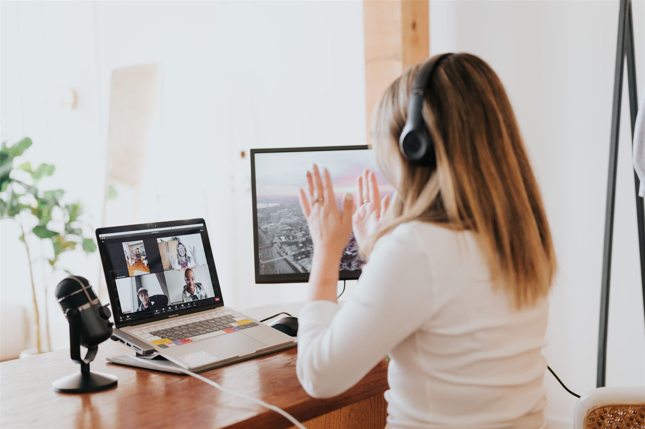 Romina Gets Branded Shot behind a blonde woman at her desk talking to people on a video call